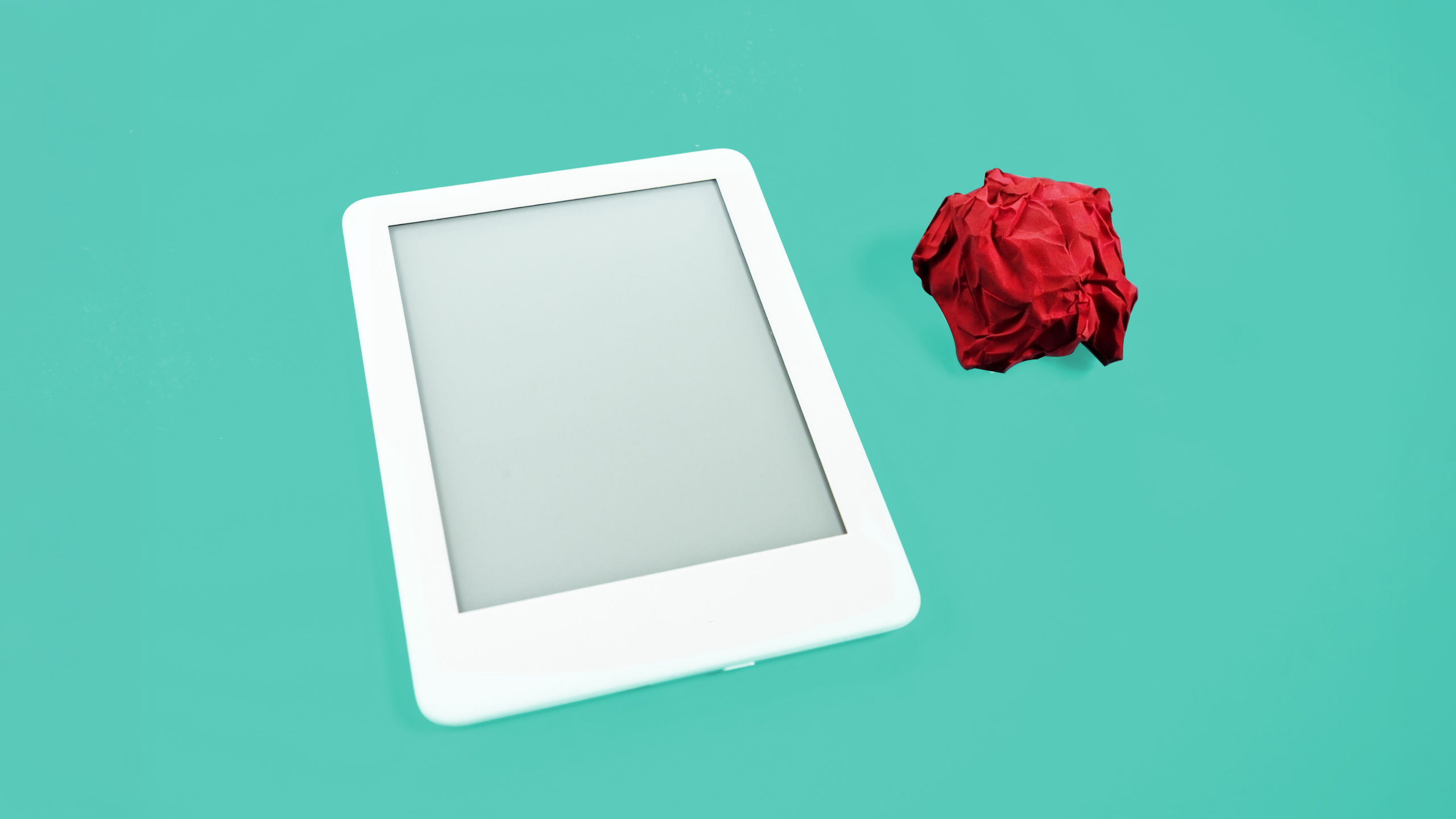 Tablet en blanco junto a papel arrugado rojo: contenido vacío que satura los canales